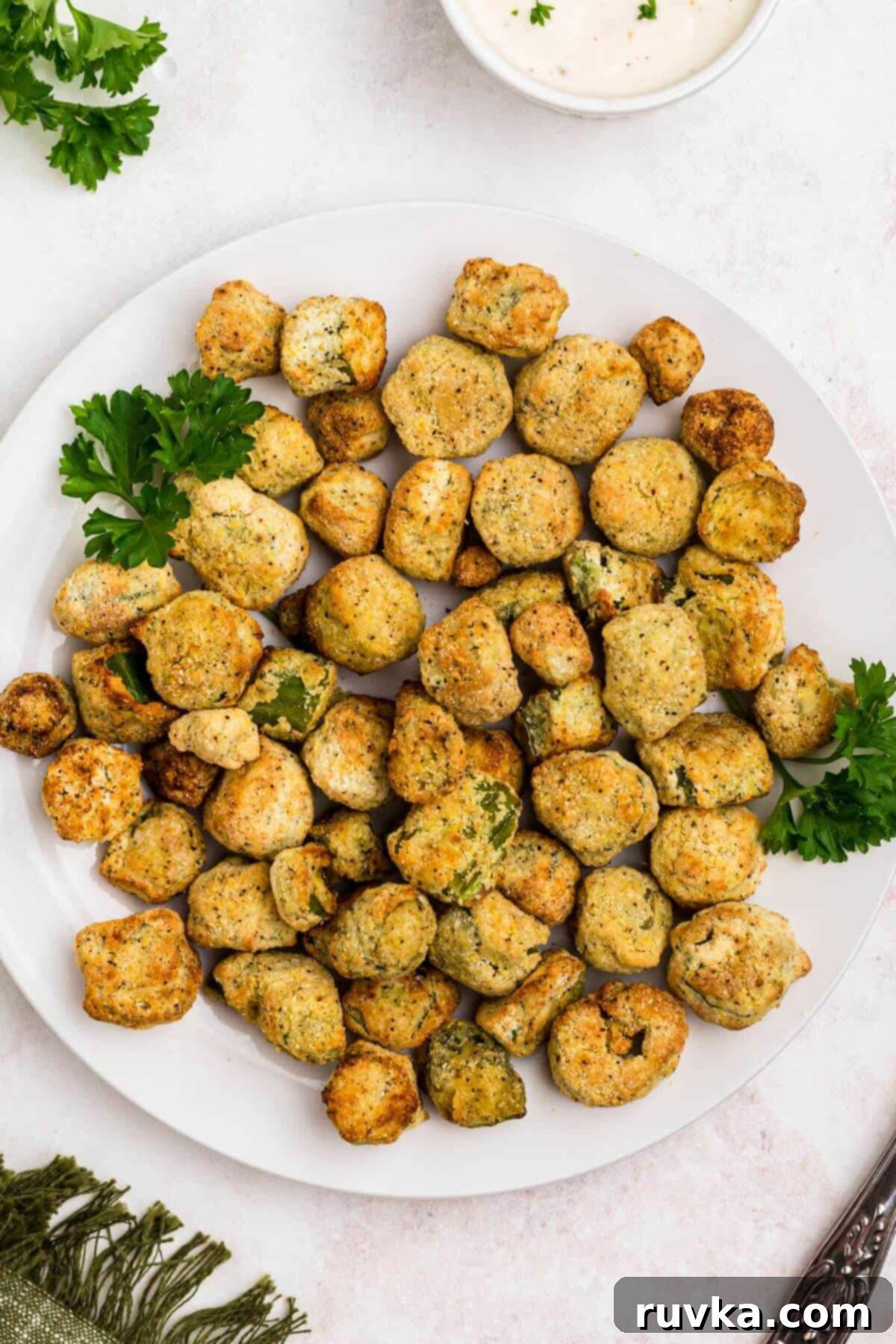 Air Fryer Magic for Frozen Okra 7 Golden breaded okra on a white plate with a small dish of ranch dressing.