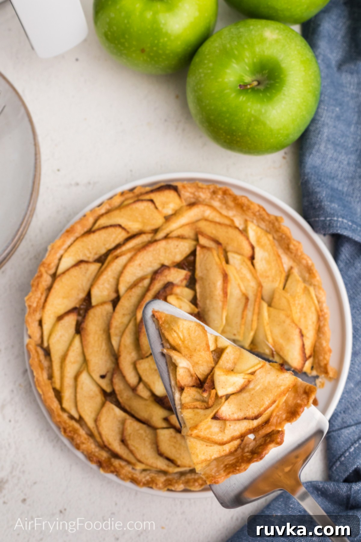 15 Cozy Autumn Air Fryer Desserts You'll Adore 3 Apple tart on a plate with a slice cut out of it.