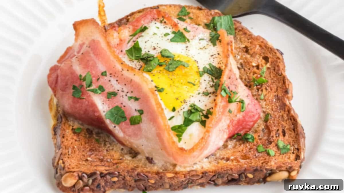 15 Effortless Breakfasts for a Perfect Start 2 A delicious air fryer breakfast sandwich featuring crispy bacon, a fried egg, and melted cheese, served on a toasted bun on a white plate, ready to enjoy.