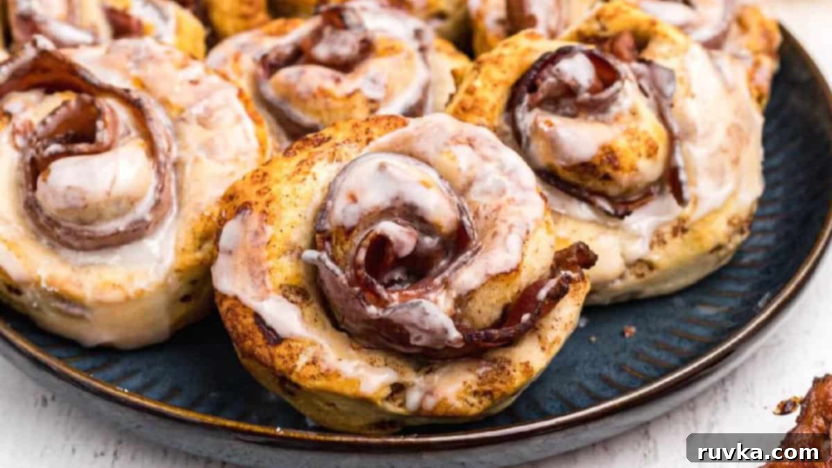 15 Effortless Breakfasts for a Perfect Start 13 Sweet and savory air fried bacon cinnamon rolls, glazed to perfection and served on a blue plate, offering a unique and irresistible breakfast fusion.