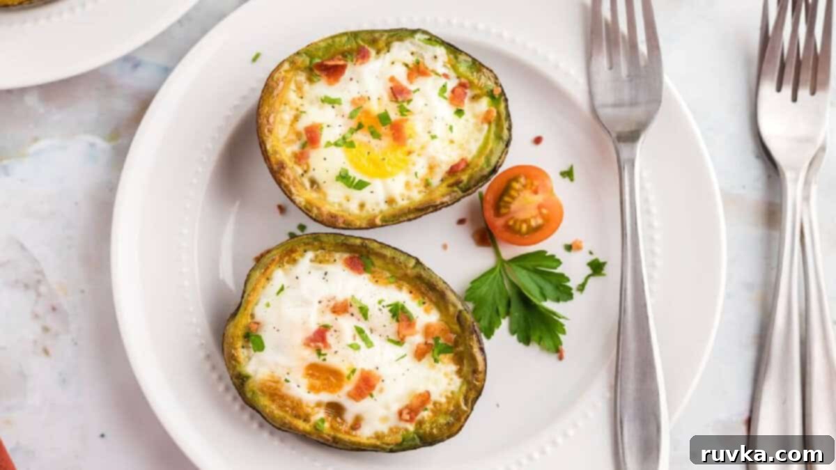 15 Effortless Breakfasts for a Perfect Start 14 Air fryer avocado eggs, with a perfectly cooked egg nestled in half an avocado, garnished with a cherry tomato and parsley, served on a plate for a healthy, low-carb breakfast.