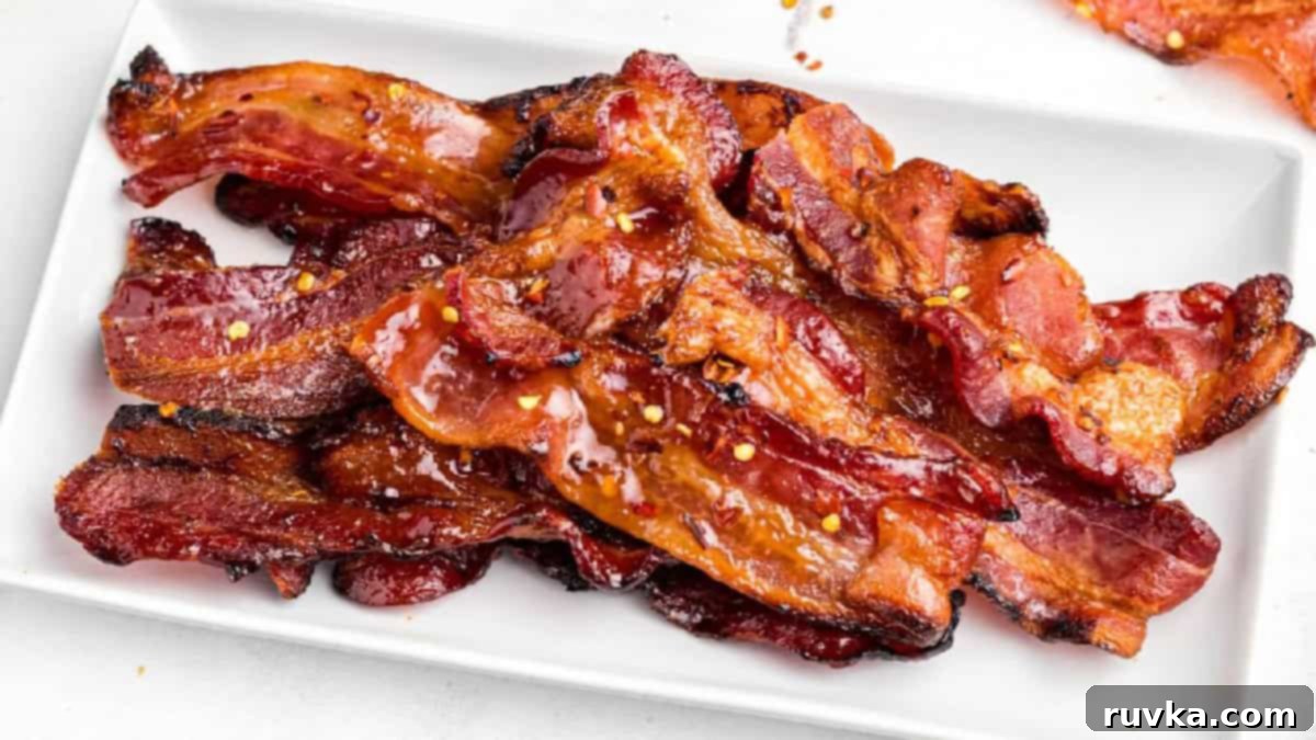 15 Effortless Breakfasts for a Perfect Start 15 Irresistible air fryer candied bacon, glistening with a sweet glaze and perfectly crisp, served on a white plate as a delightful sweet and savory treat.