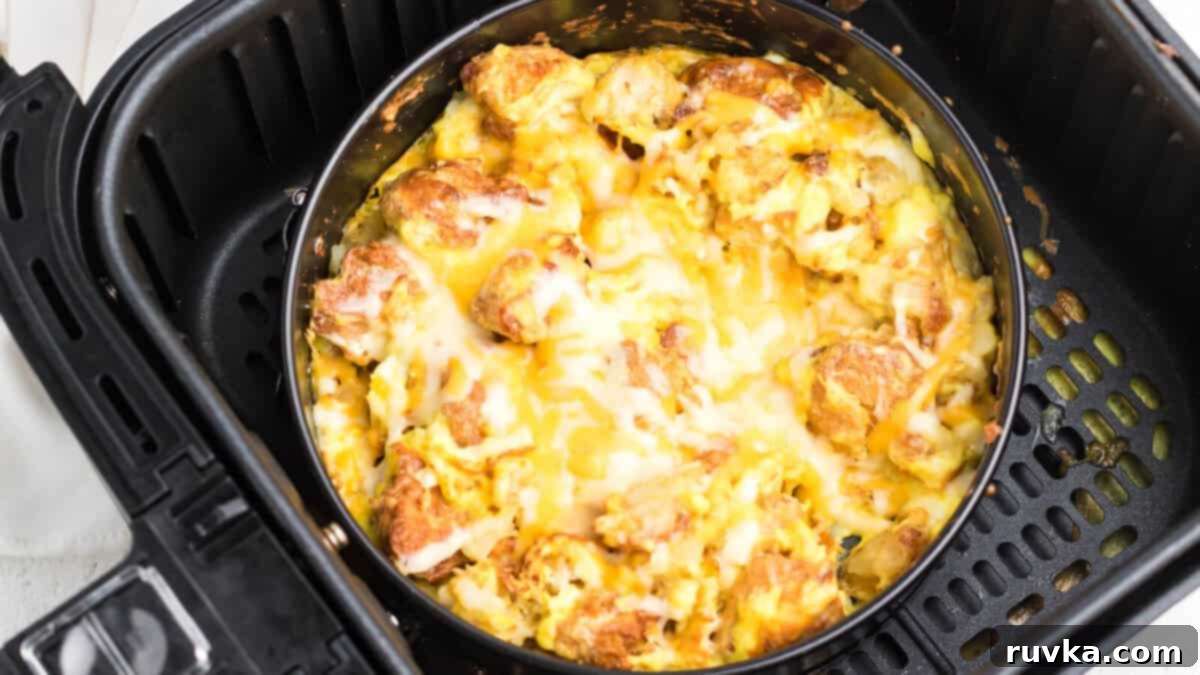 15 Effortless Breakfasts for a Perfect Start 4 A hearty air fryer breakfast bowl, generously filled with scrambled eggs, crispy potatoes, and savory sausage, nestled directly in the air fryer basket.