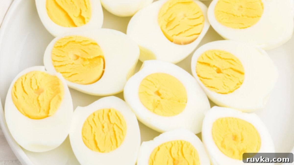 15 Effortless Breakfasts for a Perfect Start 5 Perfectly cooked air fryer hard-boiled eggs, sliced in half to reveal firm yolks, beautifully arranged on a white plate, ideal for breakfast or a snack.