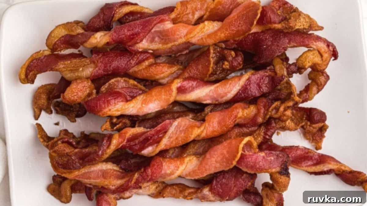 15 Effortless Breakfasts for a Perfect Start 10 Crispy and fun air fryer twisted bacon, perfectly cooked with a delightful curl, served on a plate as a unique and savory breakfast side.