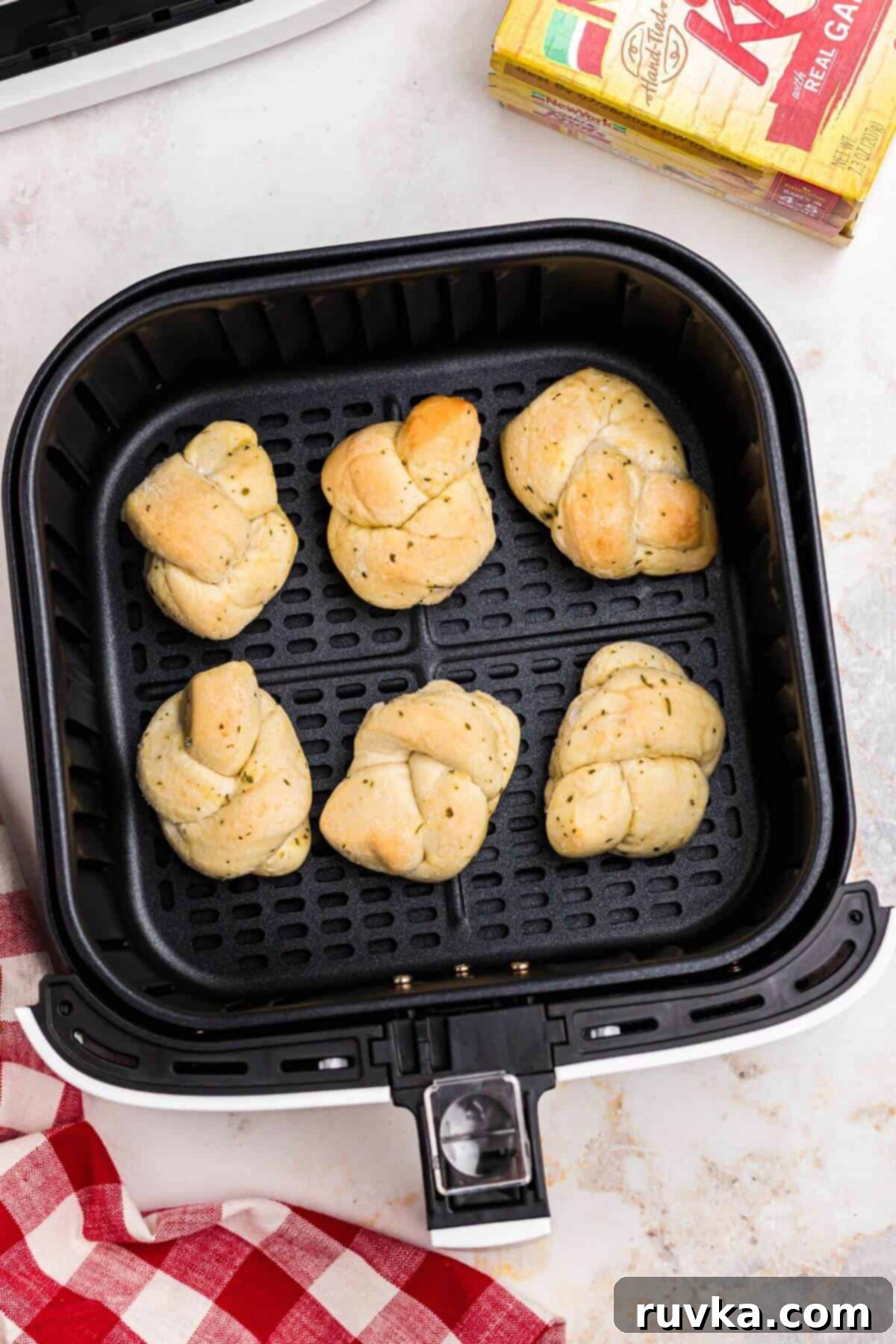 How to Air Fry Frozen Garlic Knots 4 Frozen garlic knots in an air fryer basket before being cooked.