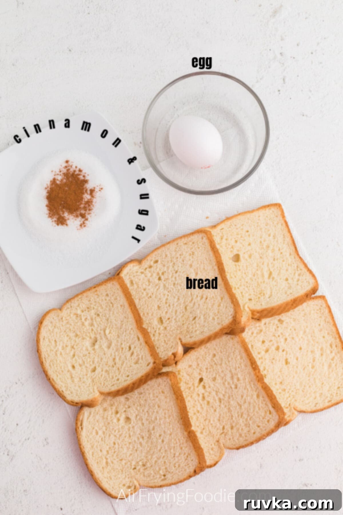 Golden Air Fryer French Toast Sticks 3 Bread, egg, and cinnamon and sugar on a white table top to make french toast sticks in the air fryer.
