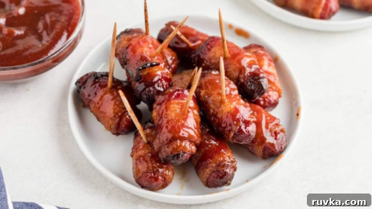 Epic Tailgate Bites Your Friends Will Love 3 bacon wrapped smokies on a white plate, ready to serve.