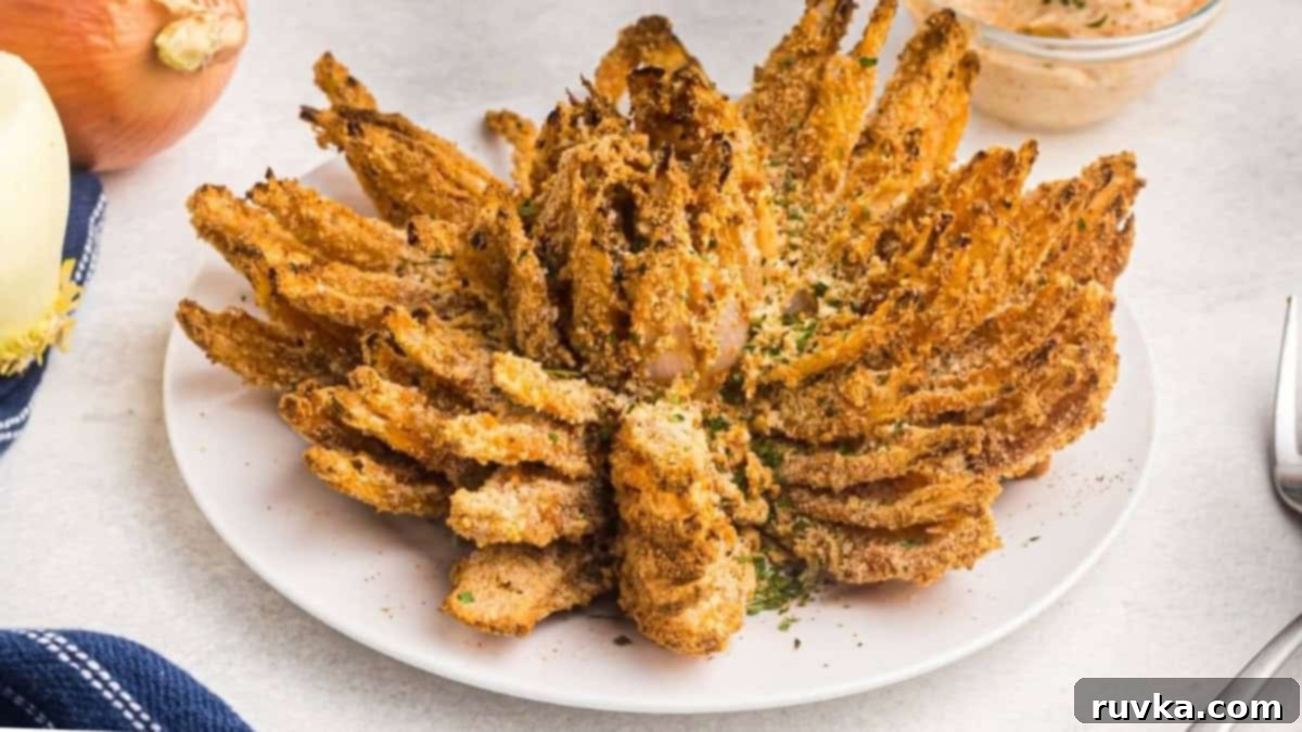 Epic Tailgate Bites Your Friends Will Love 4 Air fryer bloomin onion on a white plate ready to serve.