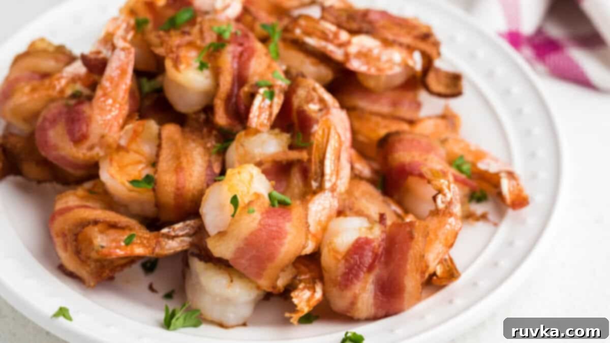 Epic Tailgate Bites Your Friends Will Love 5 bacon wrapped shrimp on a white plate, ready to serv.e