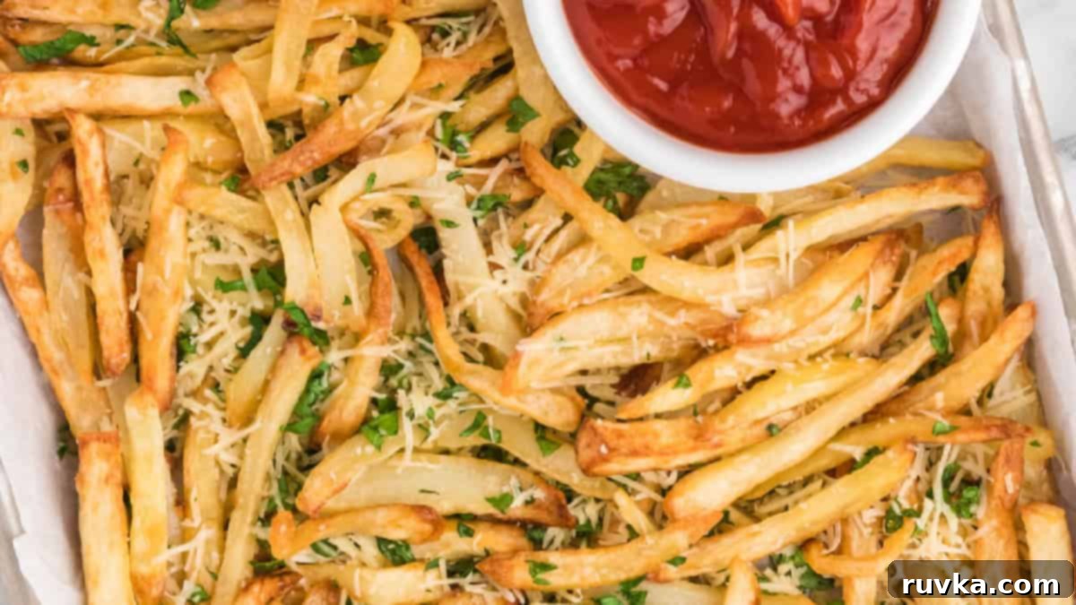 Epic Tailgate Bites Your Friends Will Love 9 Truffle fries on a tray with a side of ketchup in a white bowl.