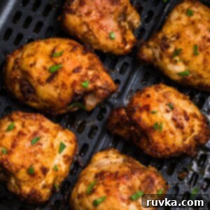 Freezer to Fabulous Air Fryer Chicken Thighs 9 olden brown crispy chicken thighs in the air fryer basket after being cooked.