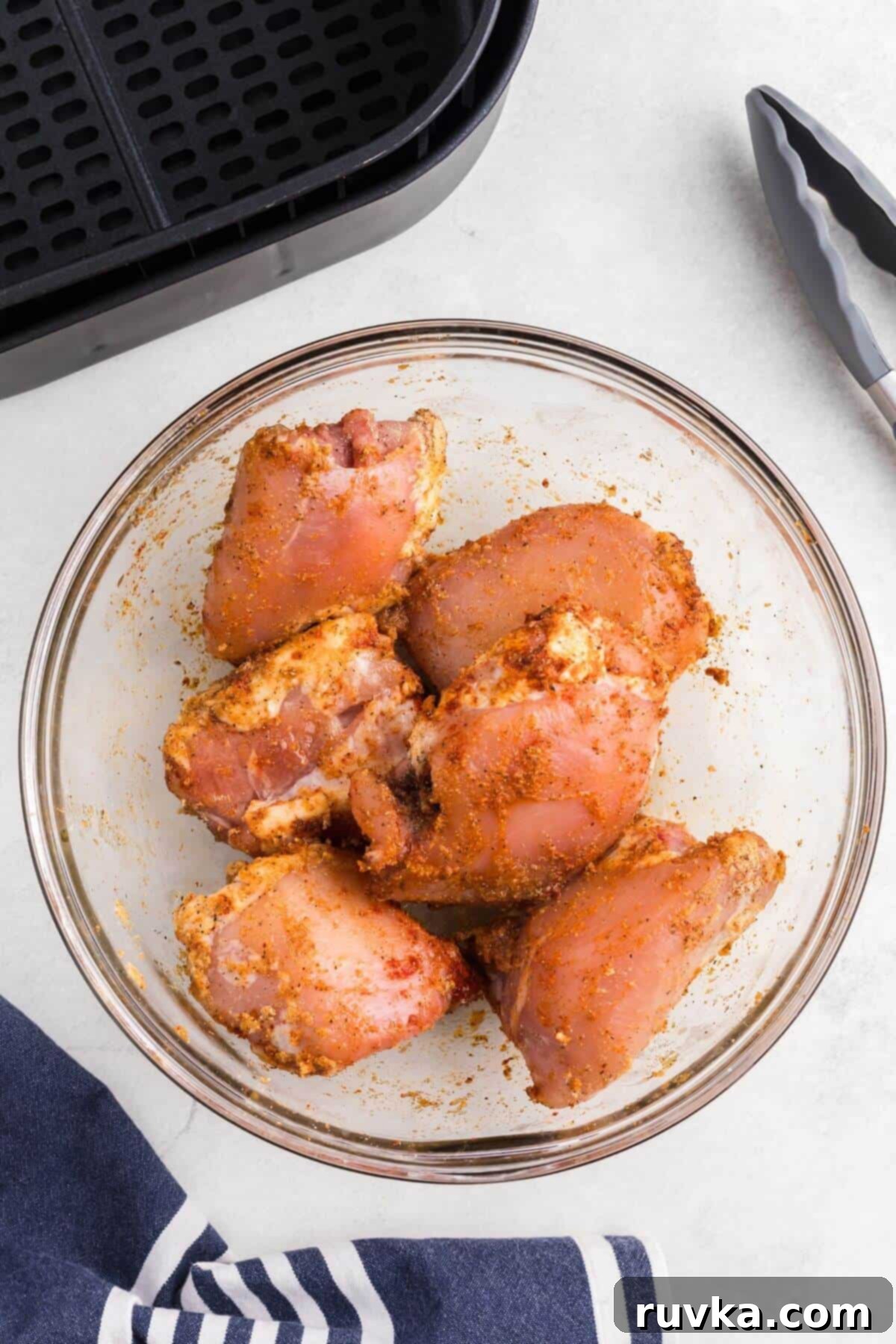 Freezer to Fabulous Air Fryer Chicken Thighs 4 seasoned chicken thighs in a clear glass bowl