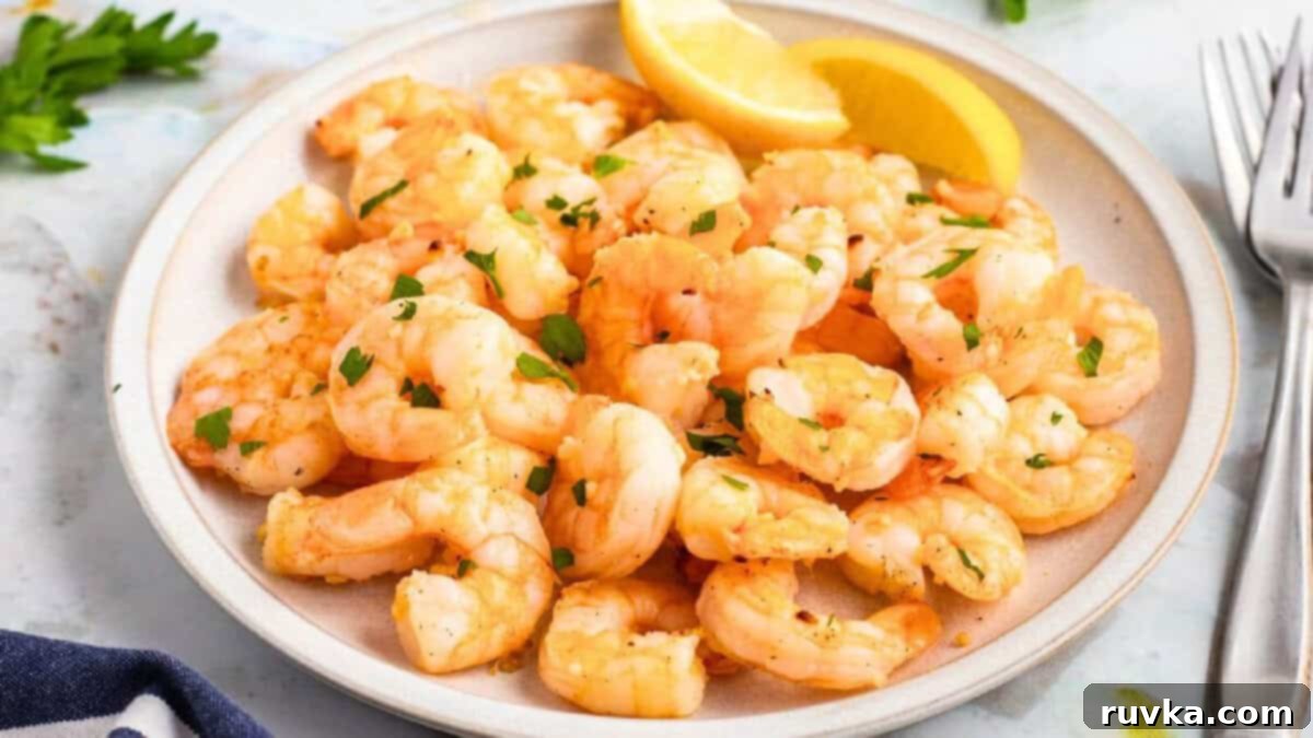 15 Foolproof Air Fryer Recipes 5 air fryer lemon garlic shrimp on a white plate with lemon wedges.
