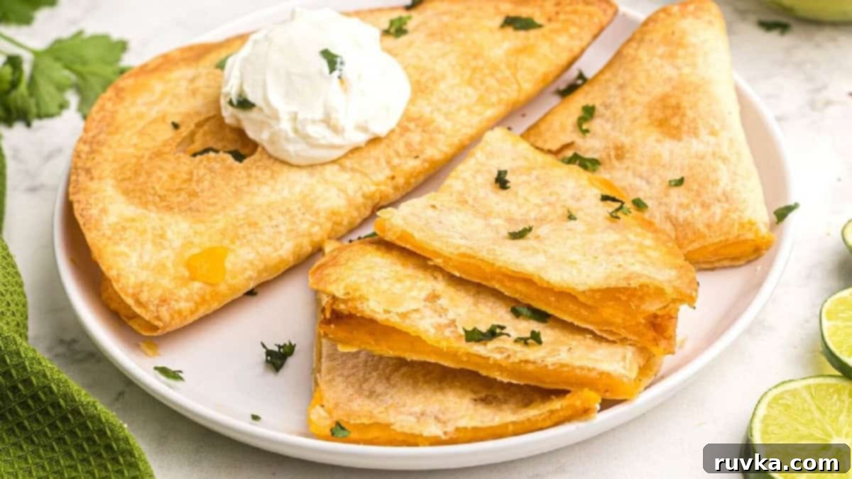 15 Foolproof Air Fryer Recipes 8 Quesadillas on a white plate with a dollup of sour cream on them.