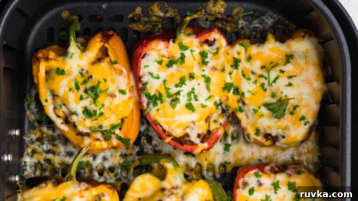 15 Foolproof Air Fryer Recipes 9 stuffed bell peppers in the basket of the air fryer, topped with cheese and fresh chopped parsley.