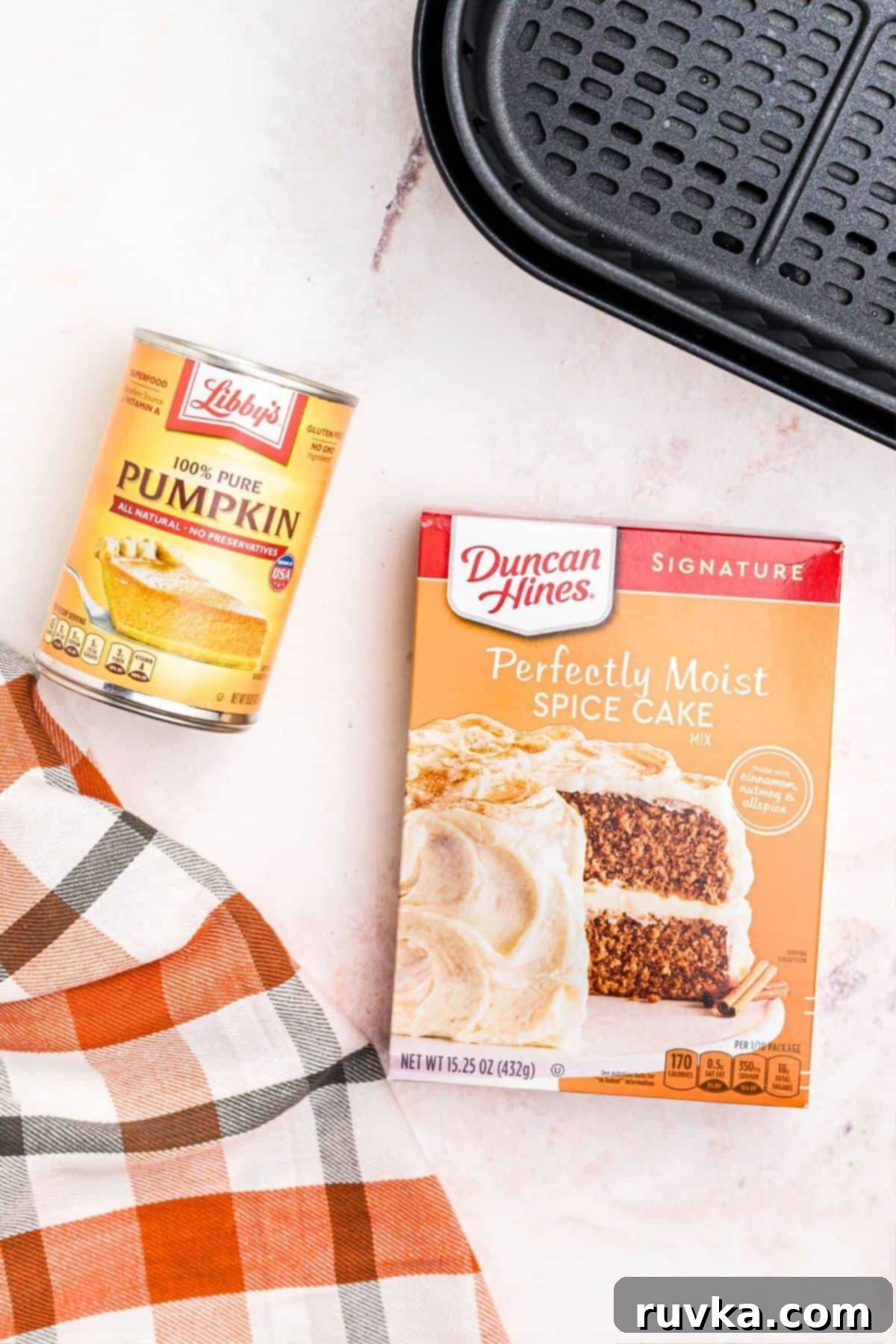 Easy Air Fryer 2 Ingredient Pumpkin Muffins 3 Box cake mix of spice cake and a can of pumpkin puree in front of an air fryer basket.