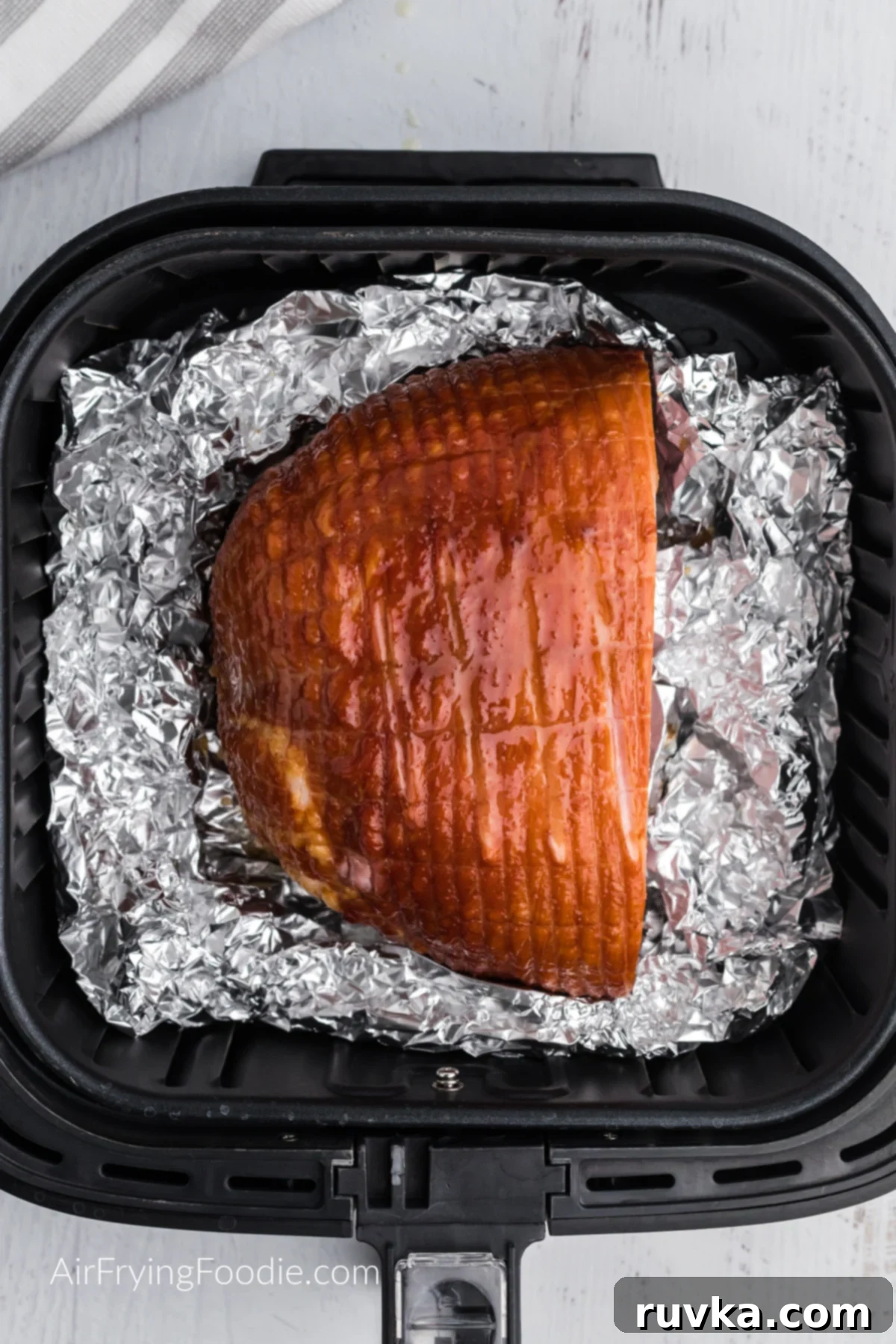 How to Safely Use Foil in Your Air Fryer 3 ham in air fryer basket laying on foil, ready to be served.