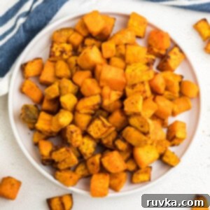 Crispy Air-Fried Sweet Potato Cubes 11 Overhead shot of air fryer sweet potato cubes on a white plate ready to serve.