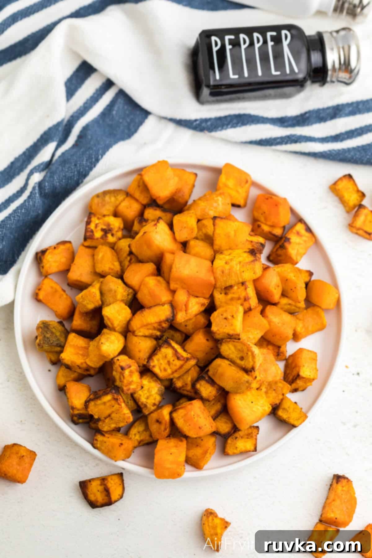 Crispy Air-Fried Sweet Potato Cubes 9 Overhead photo of crispy air fryer sweet potato cubes on a white plate, ready to serve.