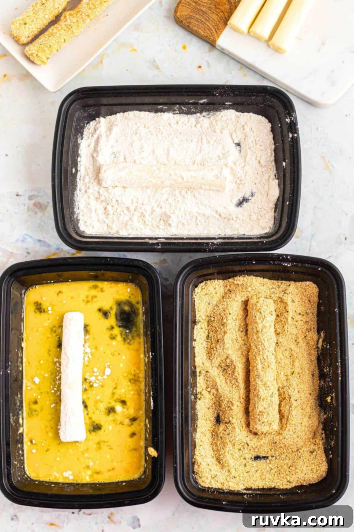 Crispy Air Fryer Mozzarella Sticks 4 Frozen cheese sticks being dredged in flour, then egg, then breadcrumbs.