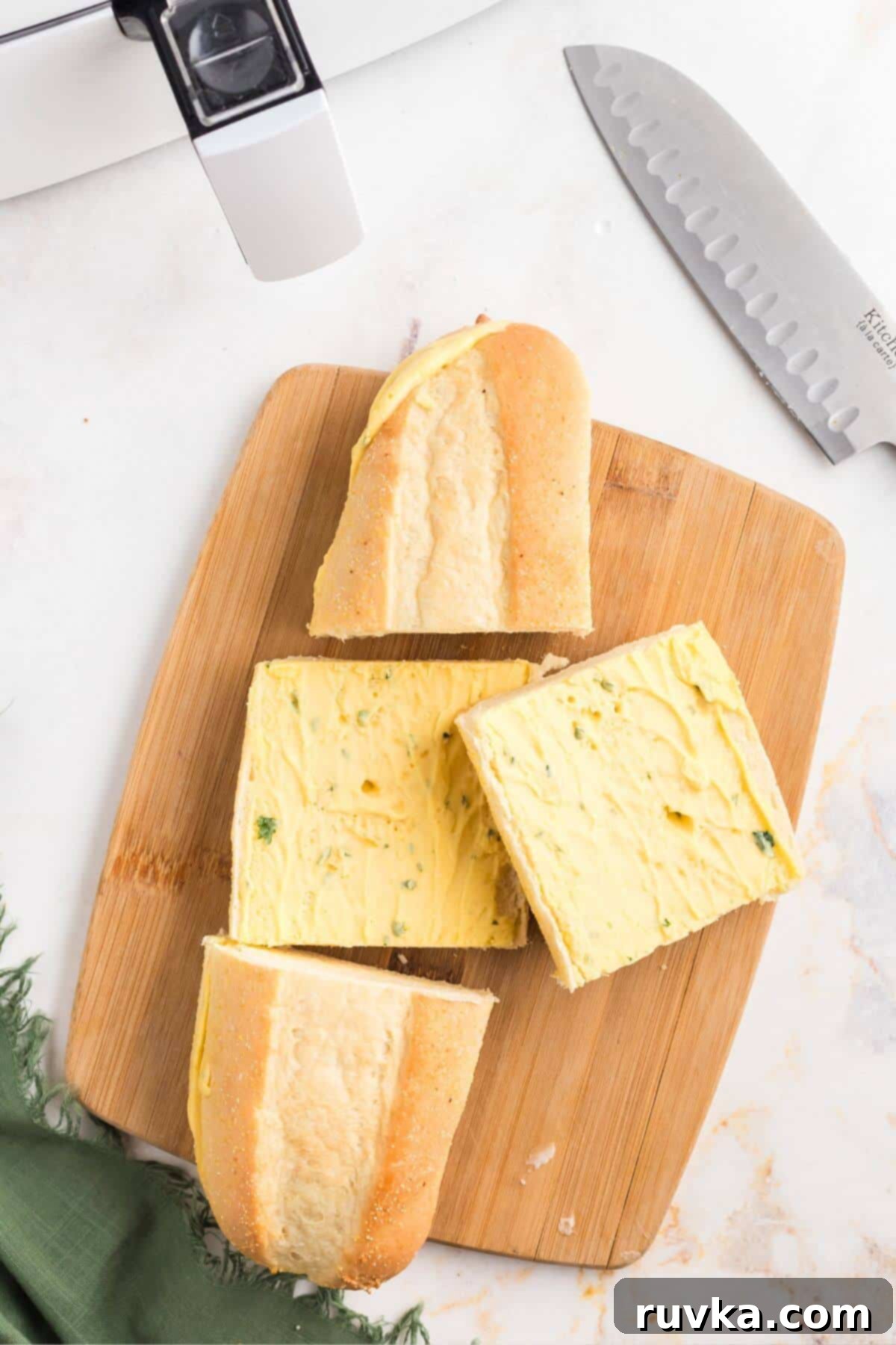 Perfect Air Fryer Frozen Garlic Bread 4 Frozen garlic bread sliced on a cutting board in front of an air fryer.
