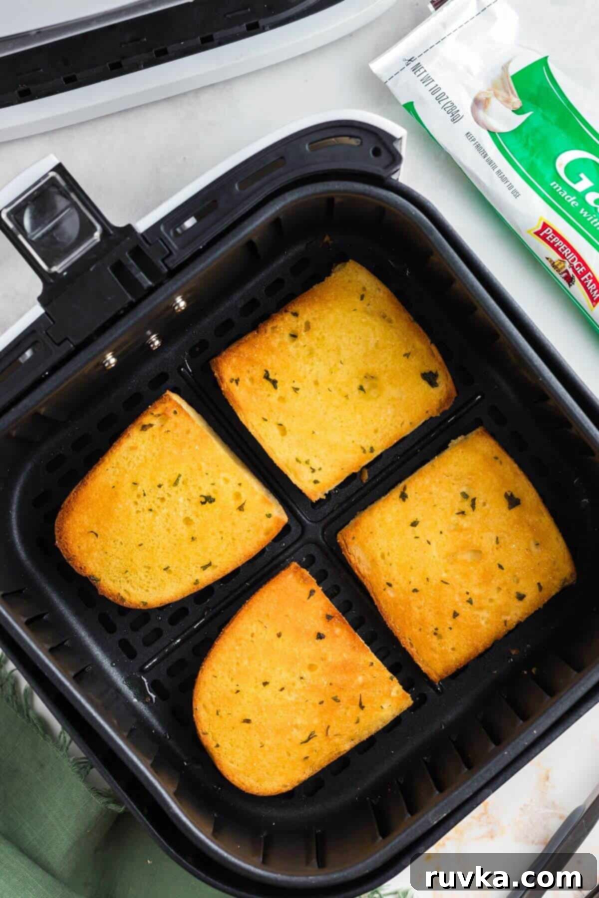 Perfect Air Fryer Frozen Garlic Bread 6 Golden crispy garlic bread slices in the air fryer basket after being cooked.
