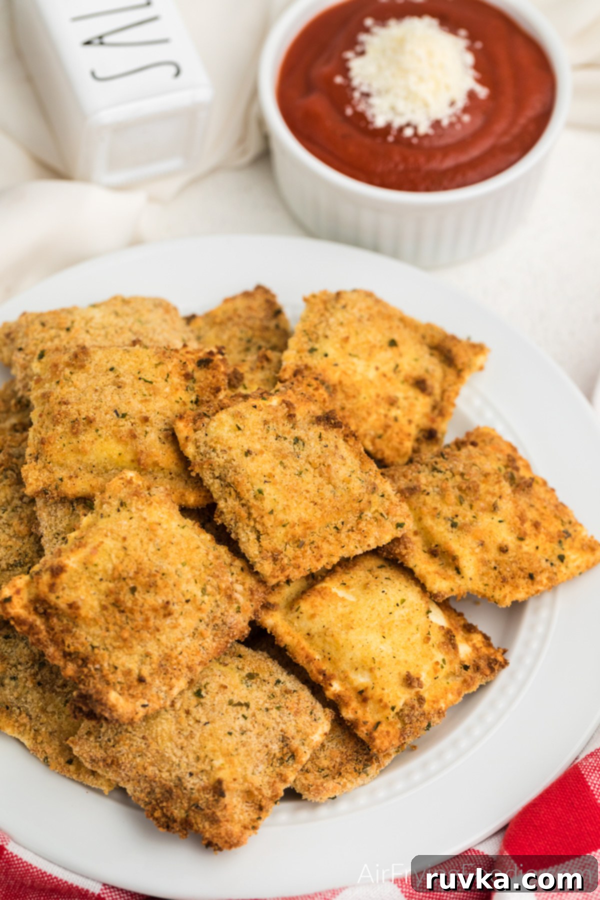 Effortless Holiday Feasts: 15 Air Fryer Recipes 12 Air fried ravioli on a white plate, ready to serve.