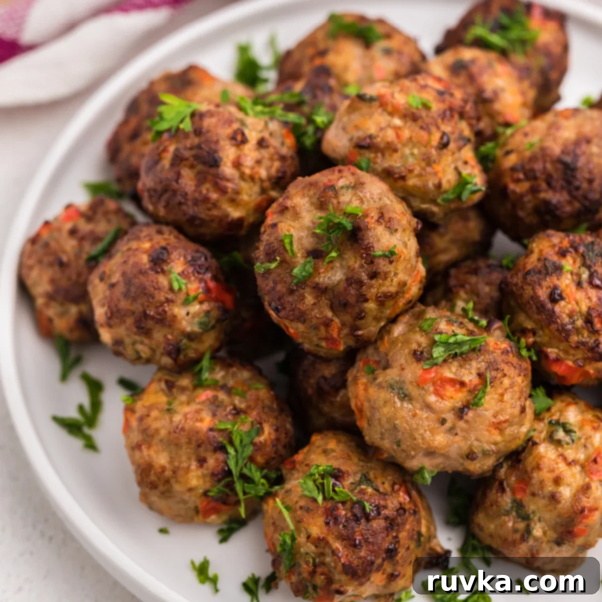 Effortless Holiday Feasts: 15 Air Fryer Recipes 15 Air Fried Turkey meatballs garnished with fresh parsley.