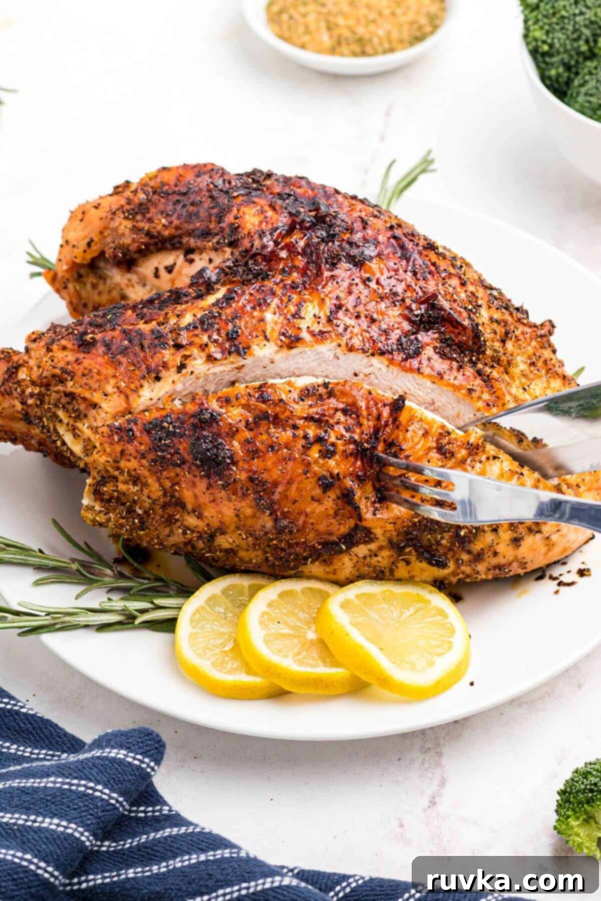 Effortless Holiday Feasts: 15 Air Fryer Recipes 3 Golden brown seasoned turkey breast being cut with a large chef knife.