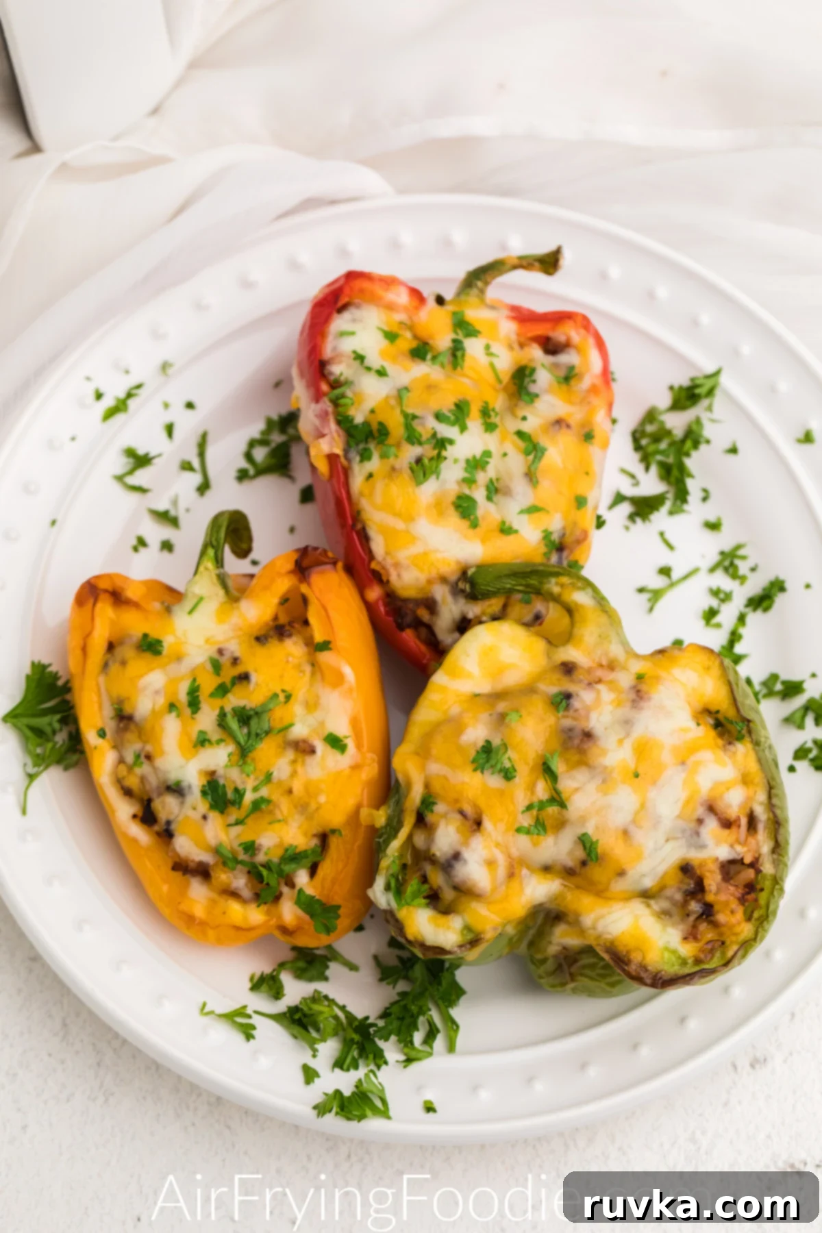 Effortless Holiday Feasts: 15 Air Fryer Recipes 4 Stuffed peppers made in the air fryer, served on a white plate.
