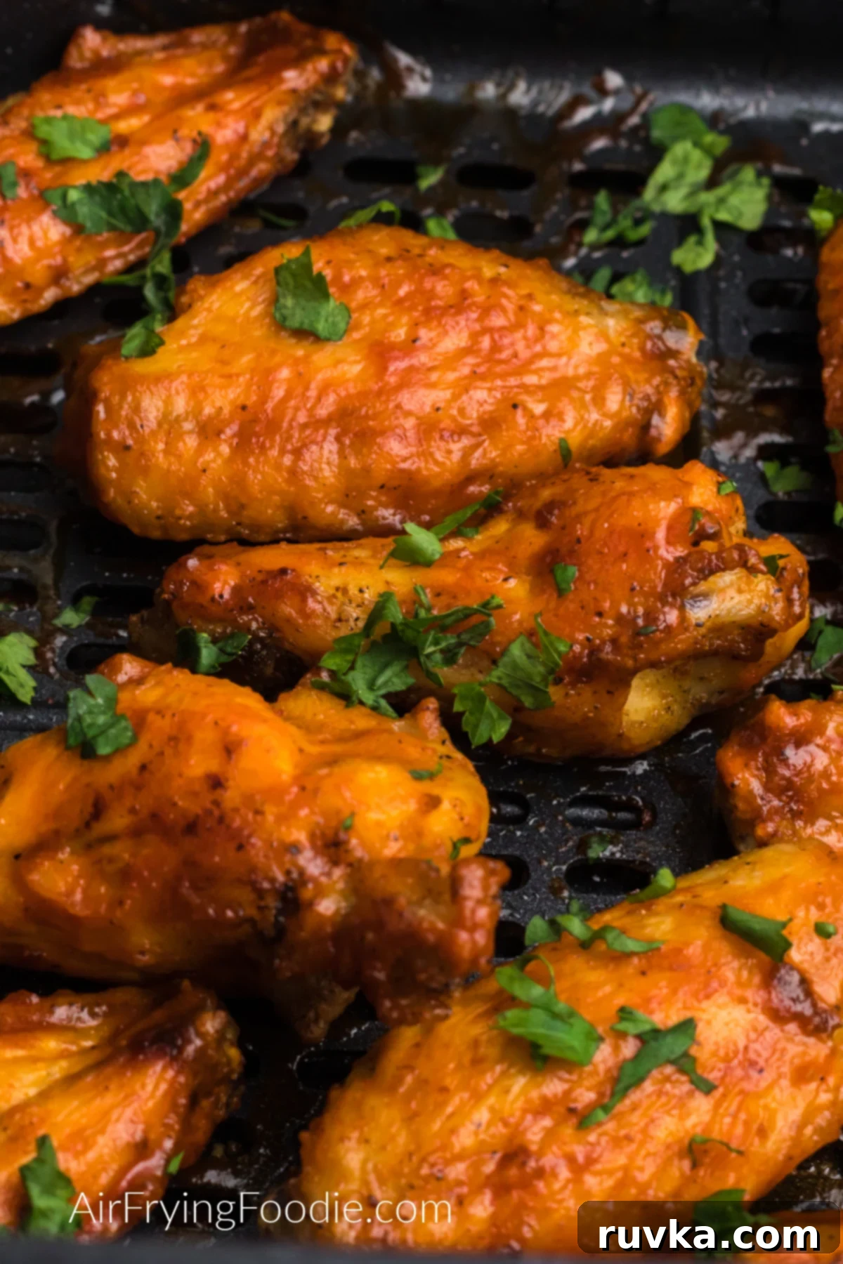 Effortless Holiday Feasts: 15 Air Fryer Recipes 9 Chicken wings in the air fryer basket garnished with fresh parsley.