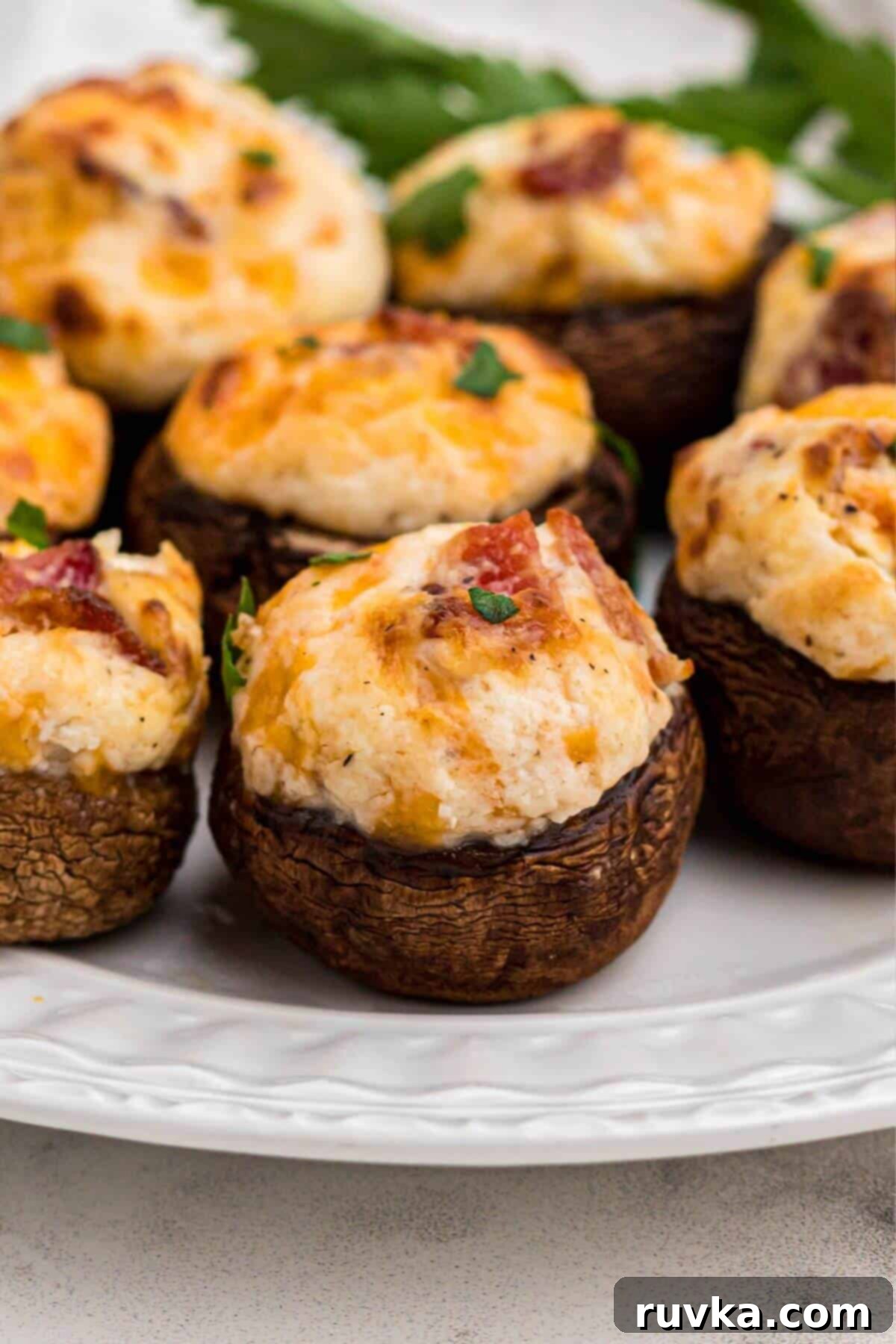 Sizzle into the New Year: 15 Air Fryer Recipes to Revolutionize Your Cooking 7 stuffed mushrooms on a white plate.