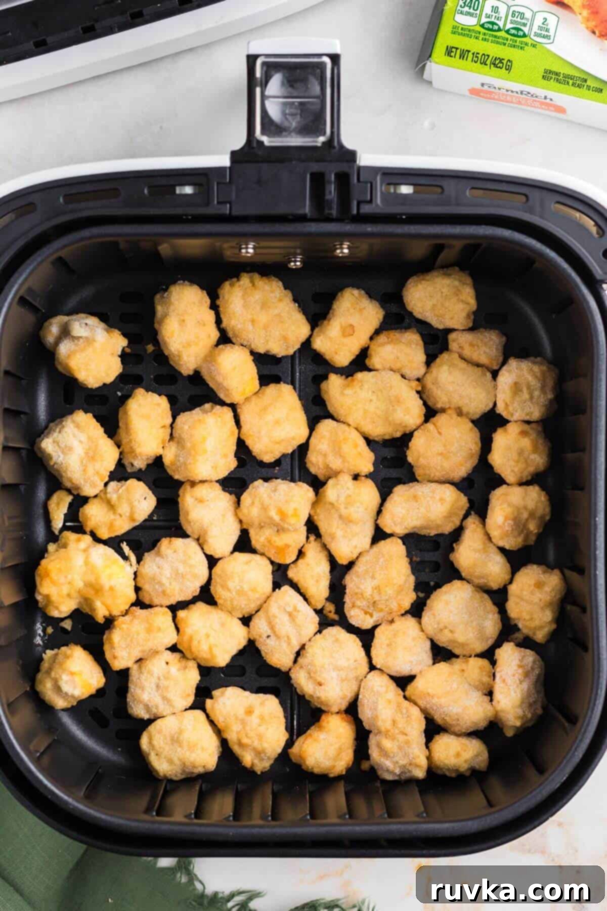 Crispy Air Fryer Frozen Cheese Curds 4 Frozen breaded cheese curds neatly arranged in a single layer in the air fryer basket.