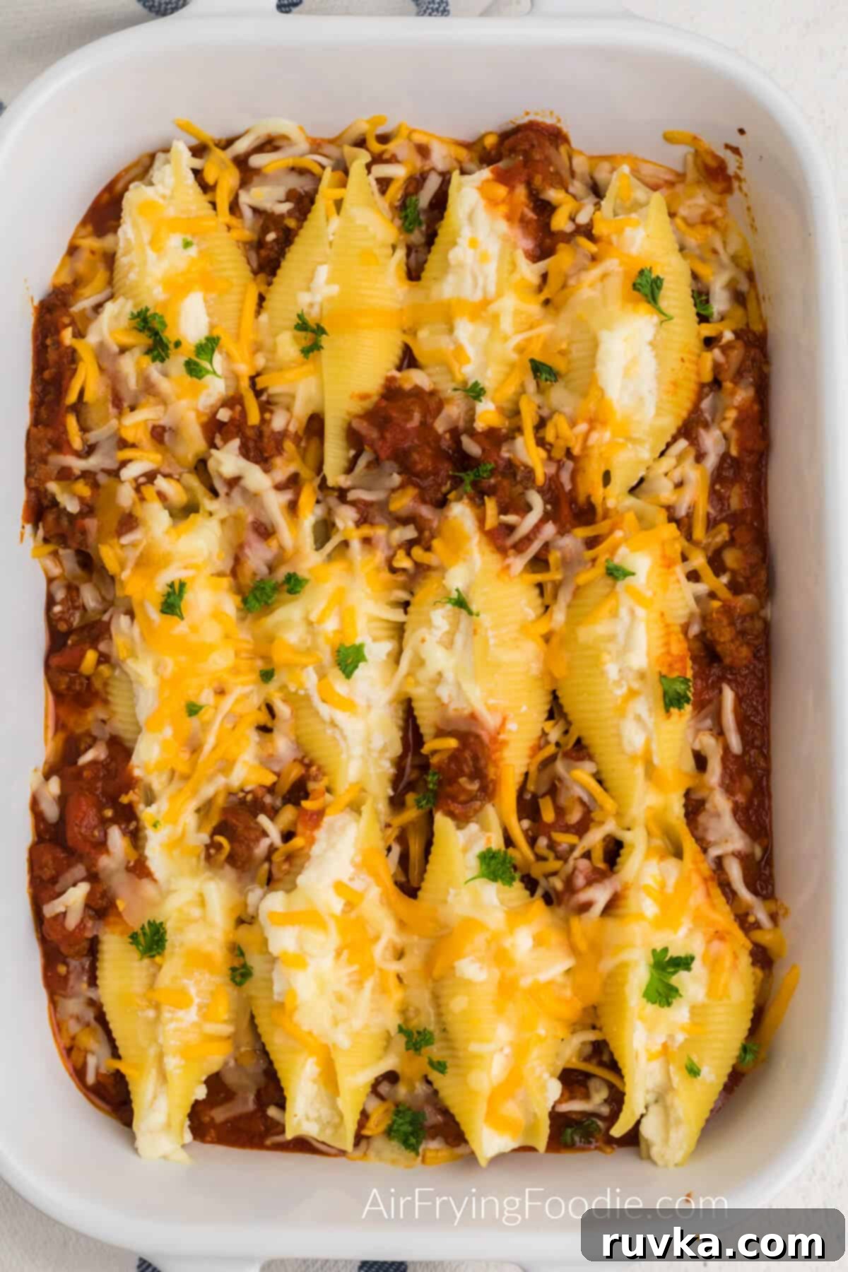 Quick and Delicious Air Fryer Lasagna Shells 2 Air fried lasagna stuffed shells in a dish, ready to serve, showcasing melted cheese and rich sauce.