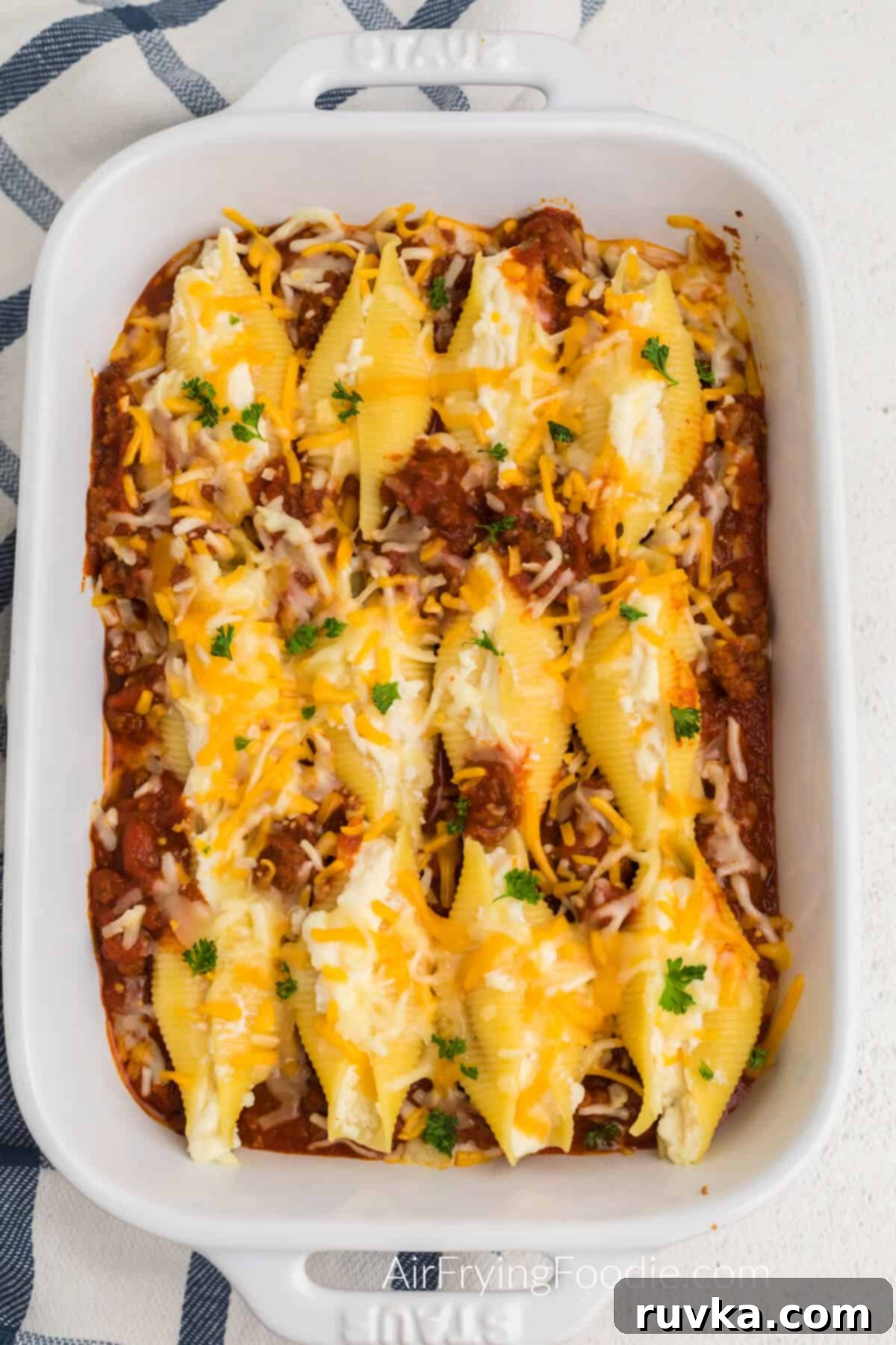 Quick and Delicious Air Fryer Lasagna Shells 3 Lasagna stuffed shells fresh from the air fryer, in a casserole dish, topped with melted cheese and ready to serve.