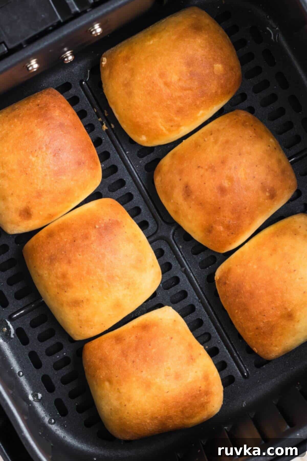 From Frozen to Fluffy: Air Fryer Dinner Rolls 5 Golden brown cooked rolls in the air fryer basket.