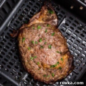 No Thaw Air Fryer Steak Perfection 7 Juicy steak in the air fryer basket after being seasoned and cooked.