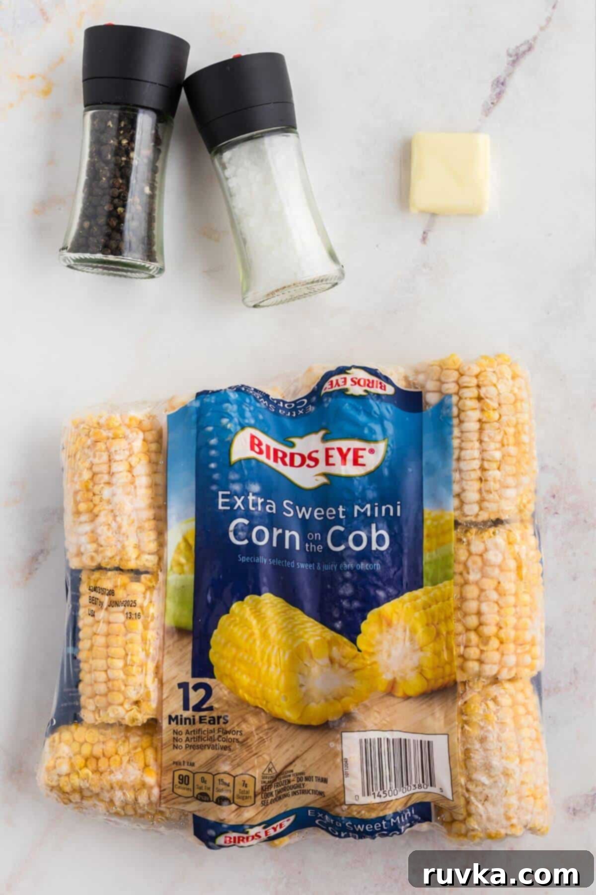 Perfect Air Fryer Frozen Corn on the Cob 3 Frozen corn on the cob with salt and pepper shakers and a slab of butter.
