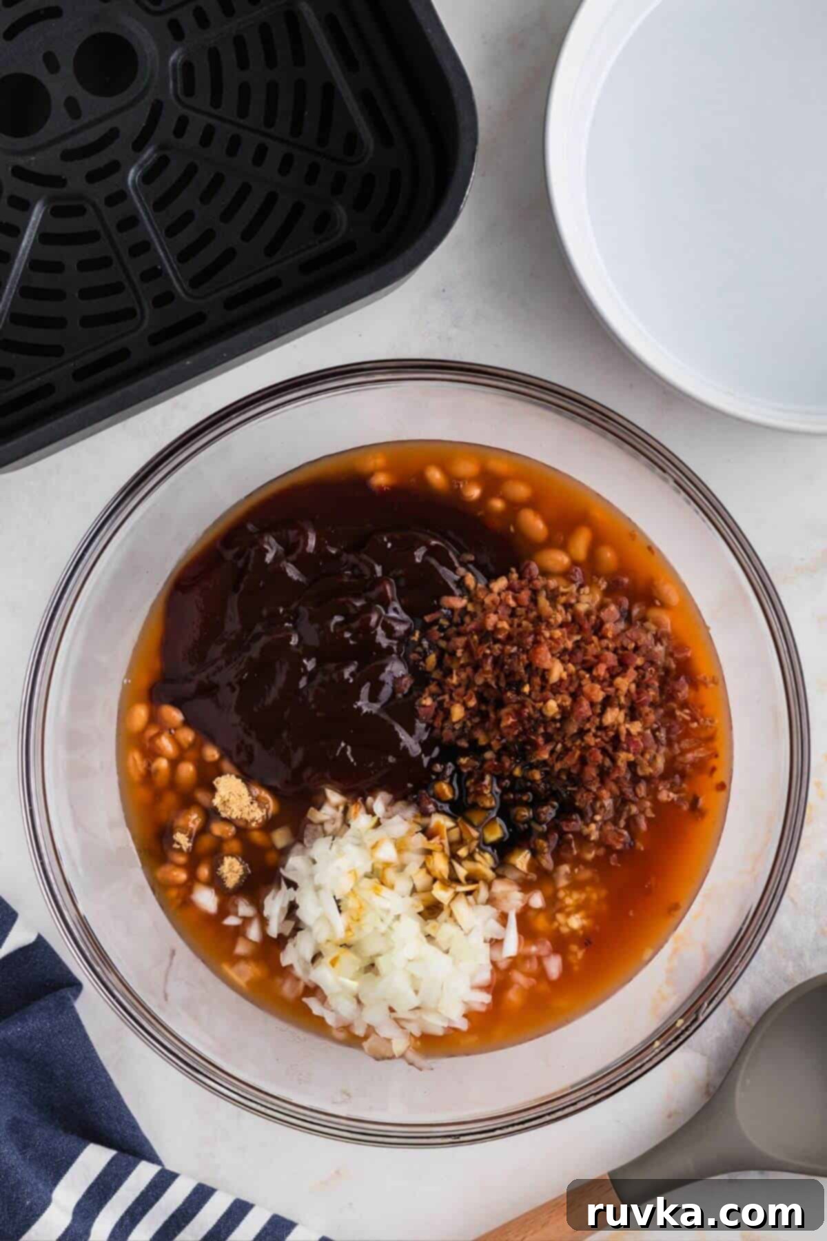 Perfect Air Fryer Baked Beans 4 Ingredients to make baked beans from scratch in a large clear glass mixing bowl.
