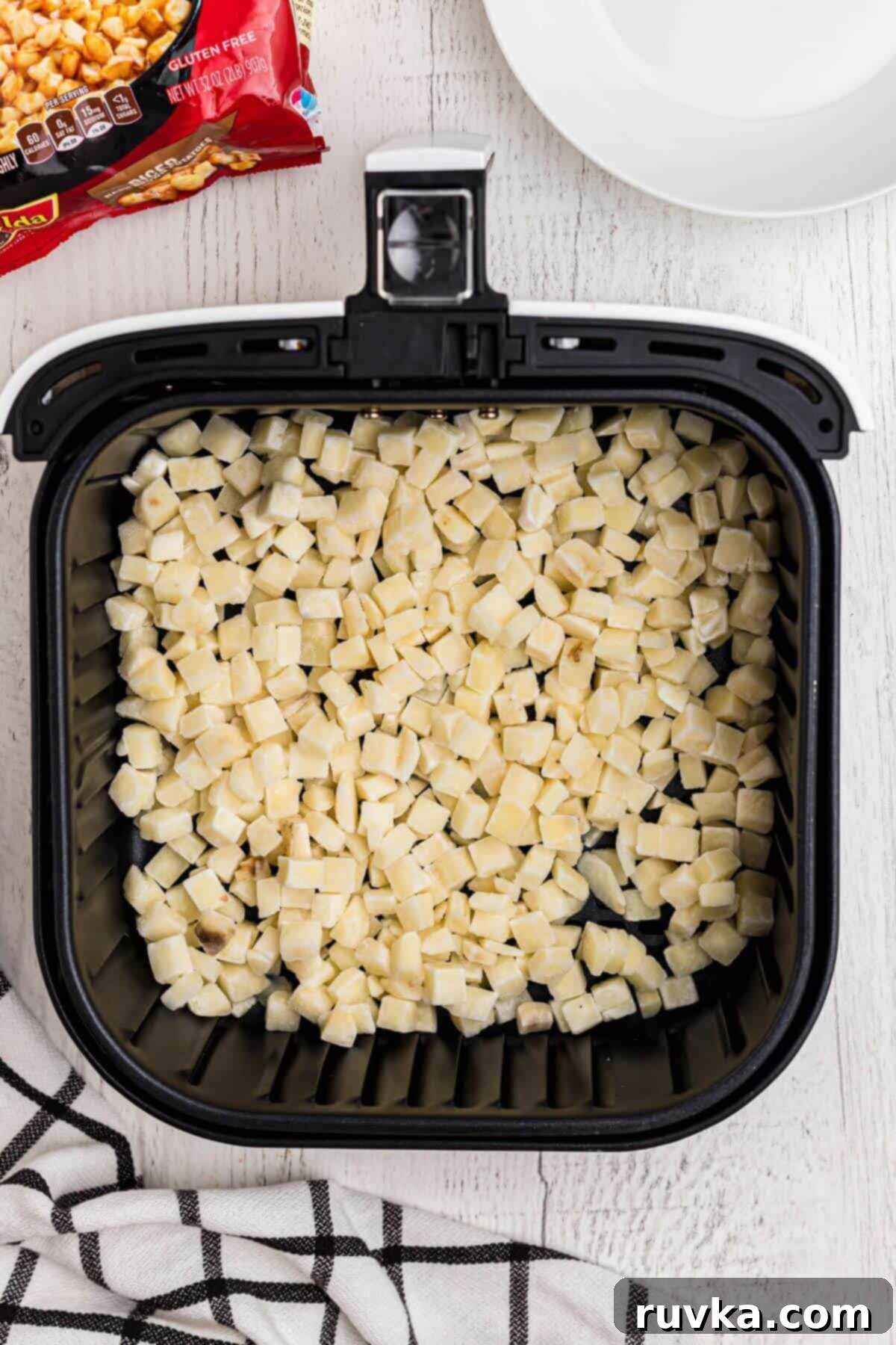 Crispy Air Fryer Frozen Potatoes 4 Frozen diced potatoes in the air fryer basket.
