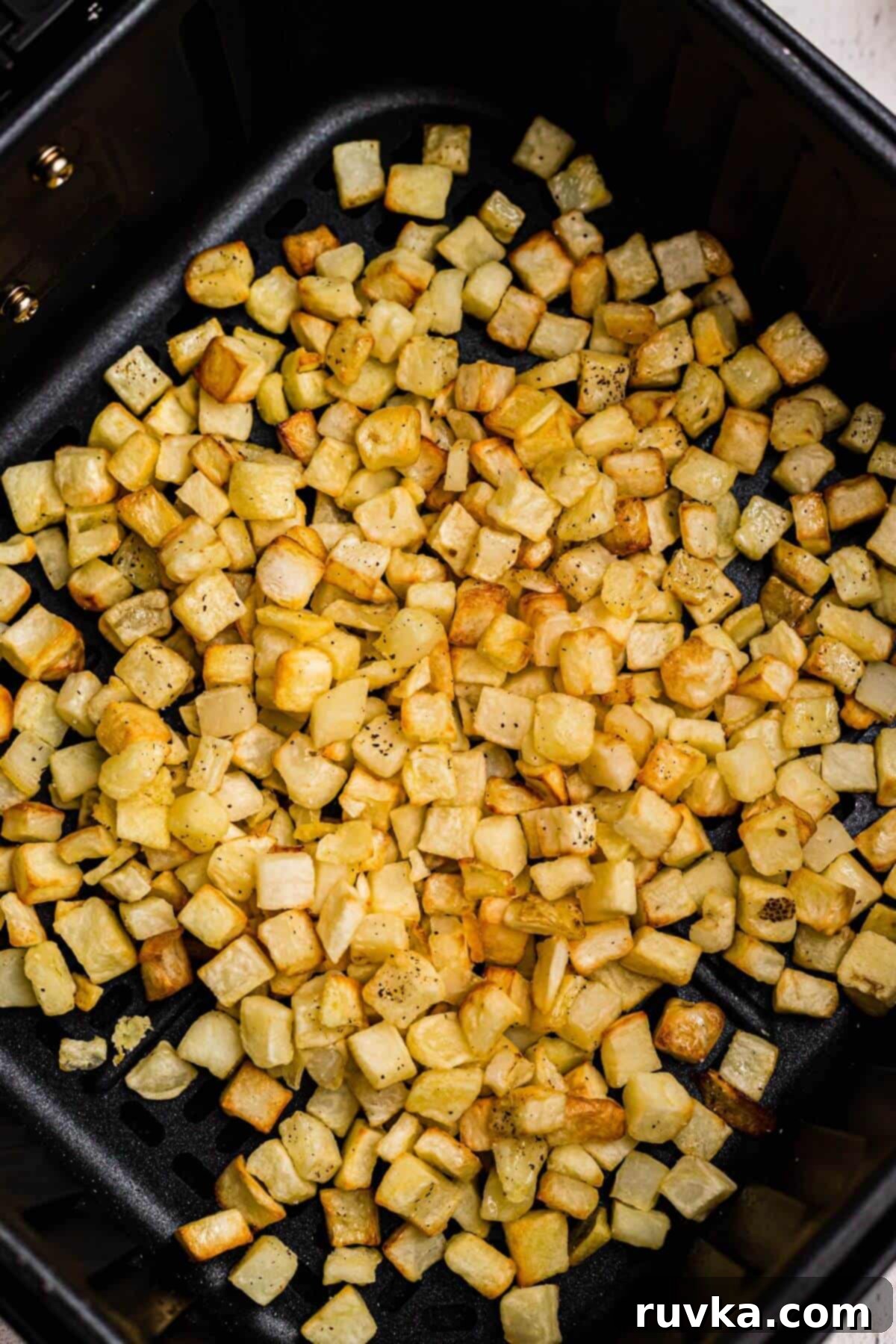 Crispy Air Fryer Frozen Potatoes 5 Golden brown and crispy diced potatoes after being cooked in the air fryer basket.