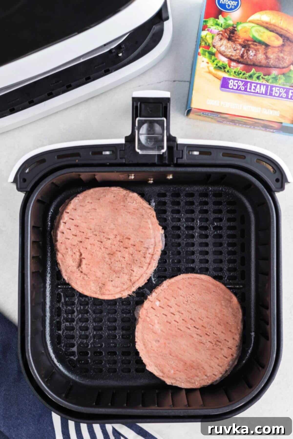 Perfect Air Fryer Frozen Turkey Burgers 4 Frozen turkey burger patties neatly arranged in the air fryer basket, ready to be cooked.