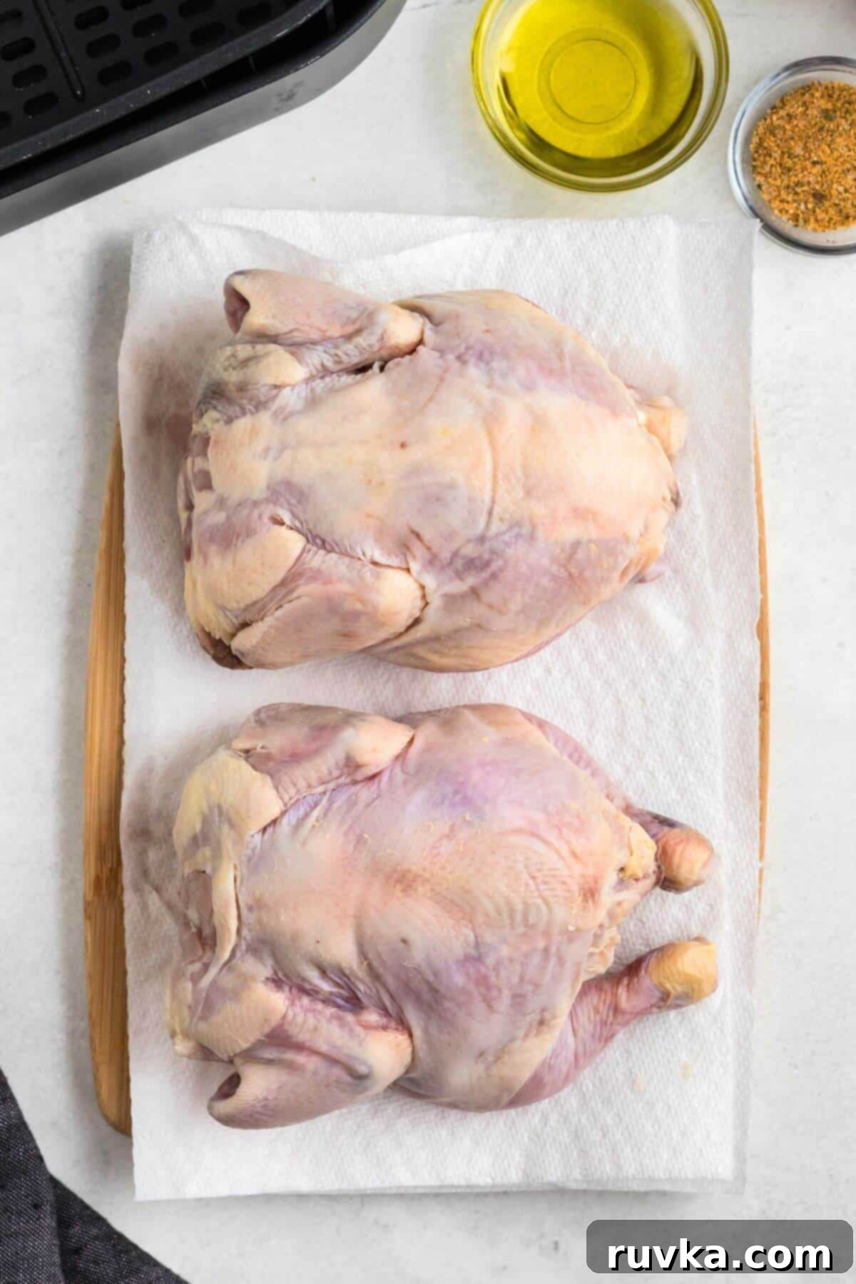 Crispy Air Fryer Cornish Game Hen 4 Uncooked Cornish hens on a paper towel before being seasoned.