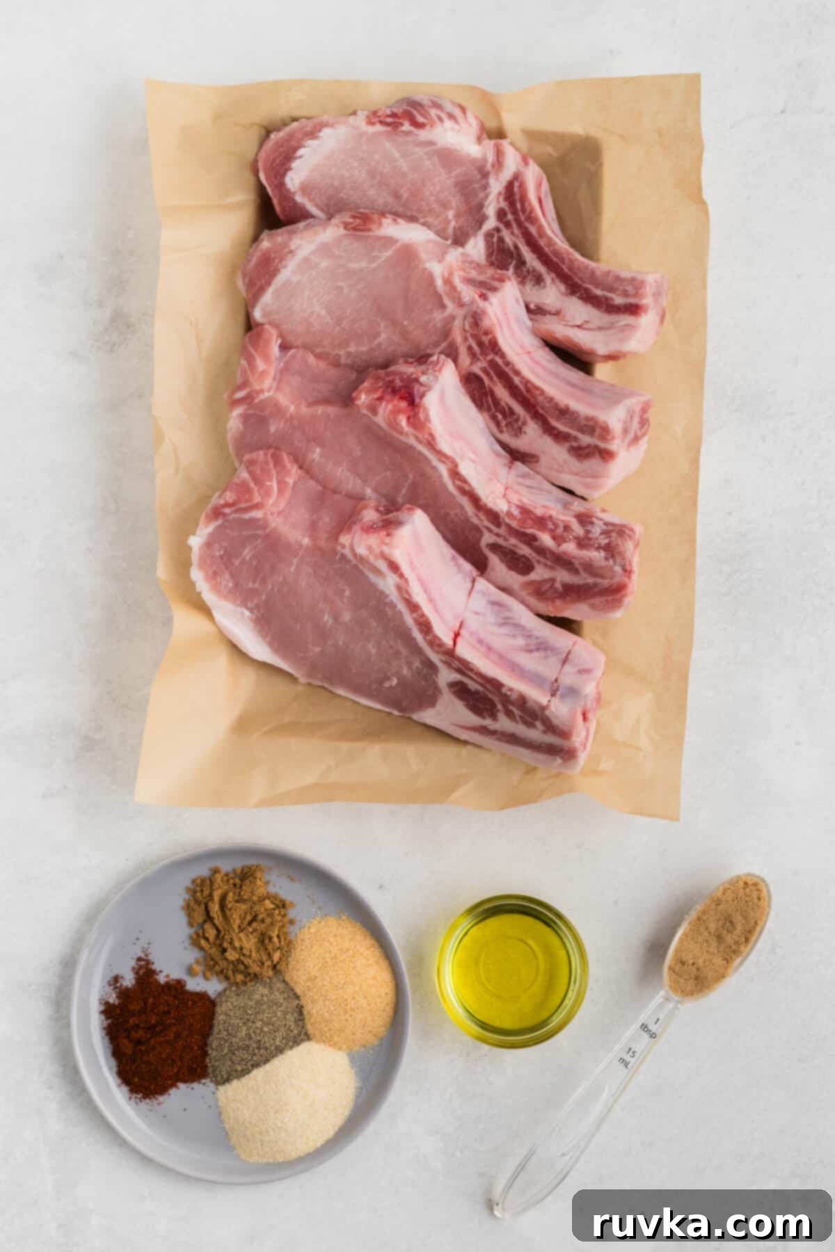 Delicious Air Fryer Pork Steaks 4 Ingredients for air fryer pork steaks laid out on a white surface.
