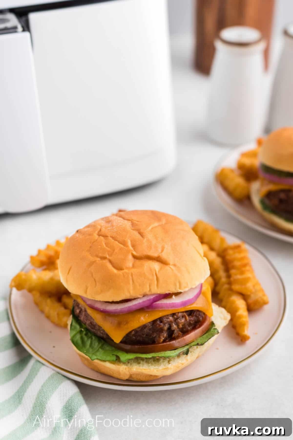 Easy Air Fryer Beyond Burger 3 Air fryer Beyond burger dressed with toppings and a bun and served on a plate with a side of fries.