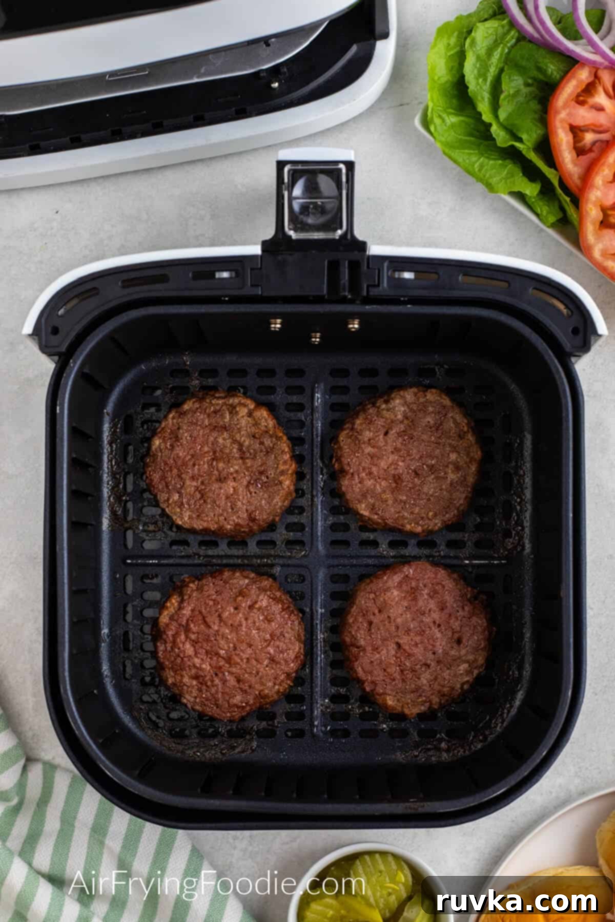 Easy Air Fryer Beyond Burger 6 Air fried Beyond burgers in the basket of the air fryer.