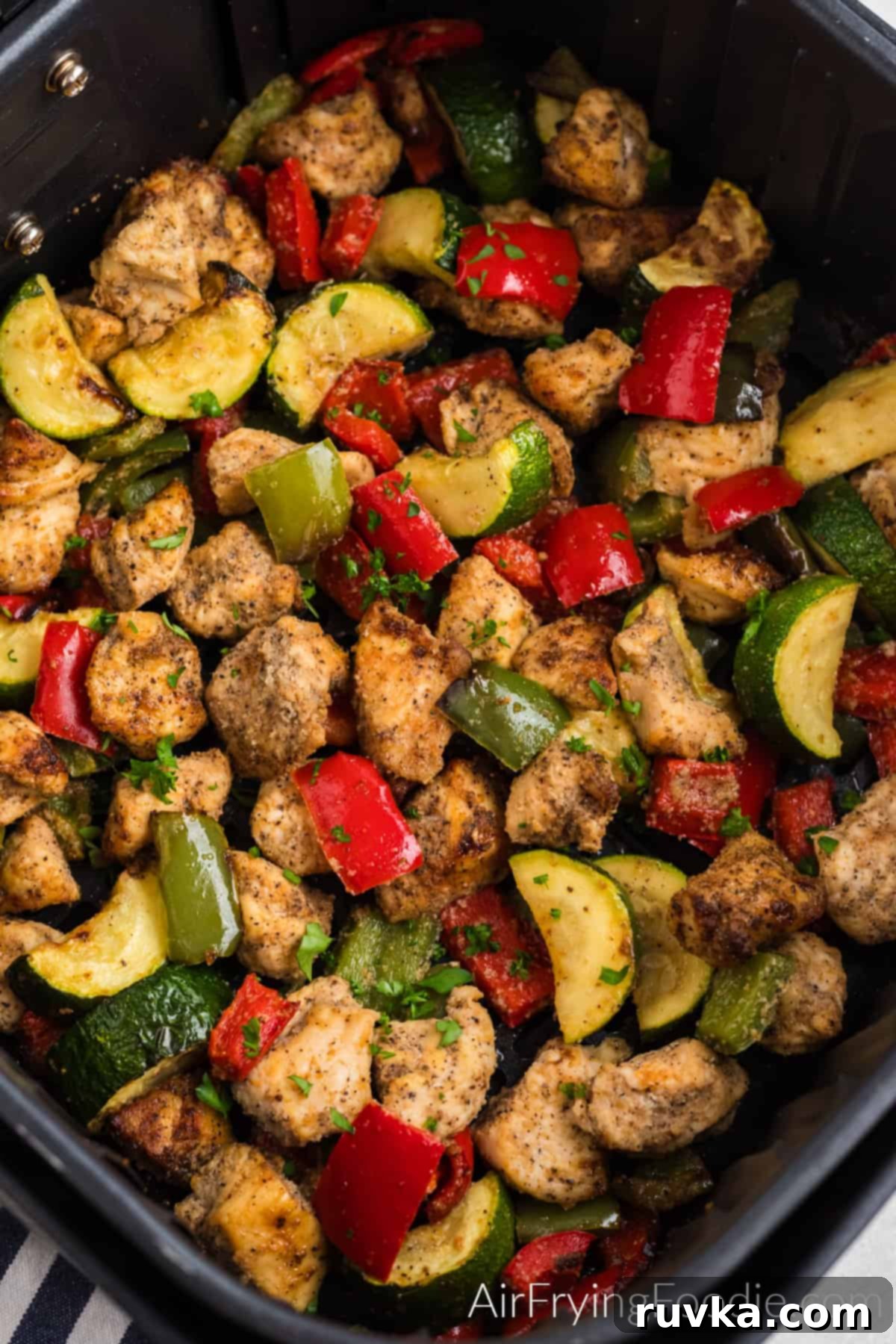 Crispy Air Fryer Chicken and Roasted Vegetables 5 air fried chicken and vegetables in the basket of the air fryer.