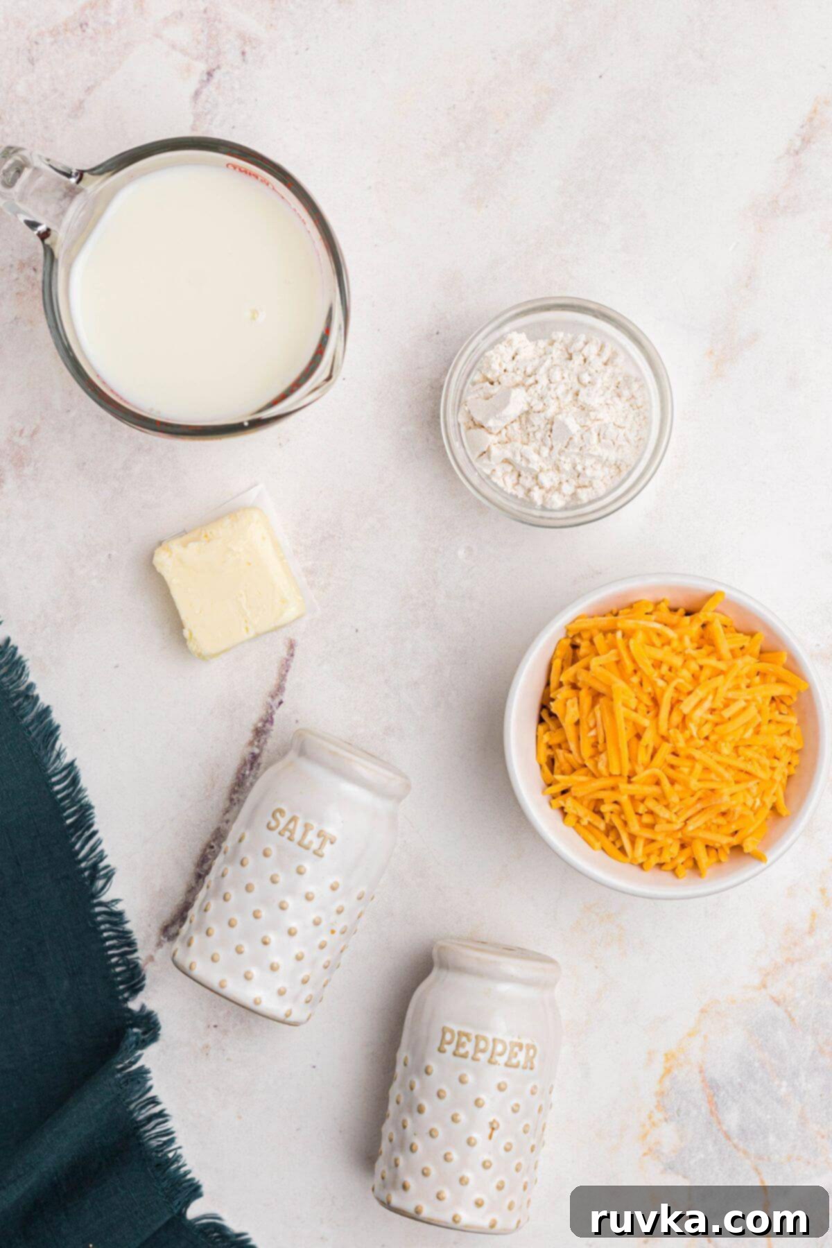 Creamy Cheese Sauce 3 Ingredients measured out on a marble table.