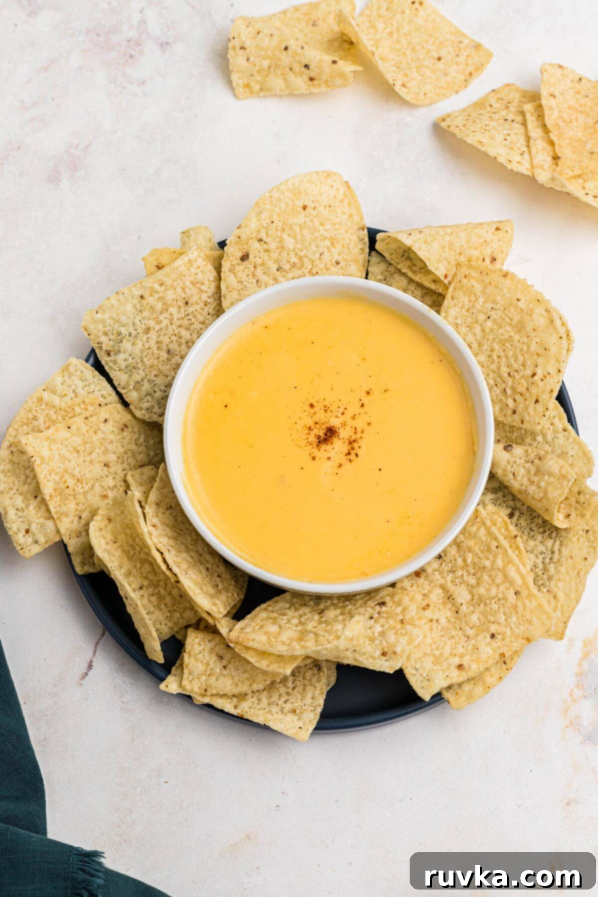 Creamy Cheese Sauce 9 Creamy cheese sauce in a white bowl surrounded by tortilla chips.